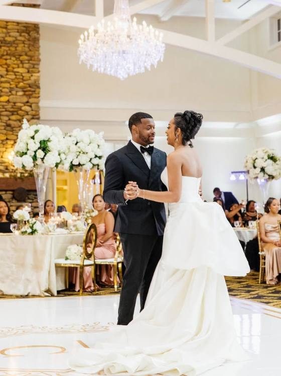 Couple first dance on a custom monogram dance floor wrap in a ballroom