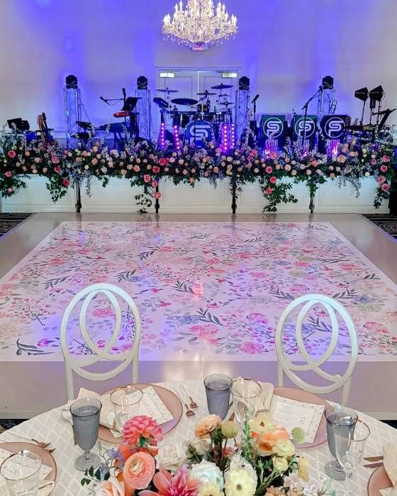 Floral-pattern dance floor wrap in front of a live band stage